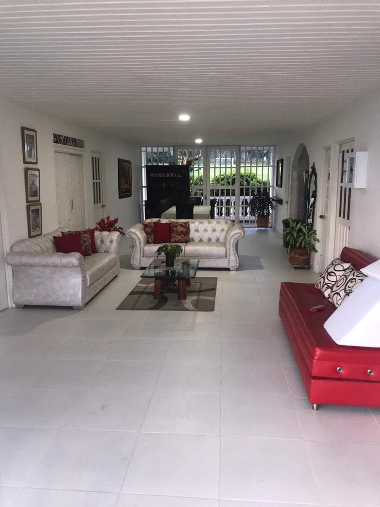 Sala de estar con sofás blancos y rojos