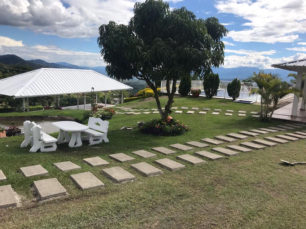 Mesa junto al estanque con kiosco y piscina de fondo
